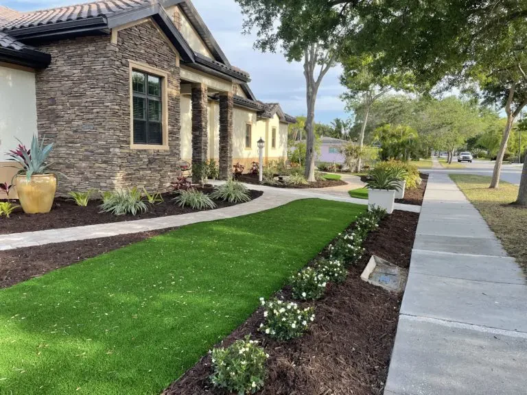Poolside artificial turf with paver pads and clean coping transitions.